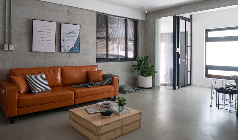  Phòng khách có tường bằng xi măng kết hợp với ghế sofa màu nâu cam và pallet gỗ mang đến cái nhìn khác biệt.