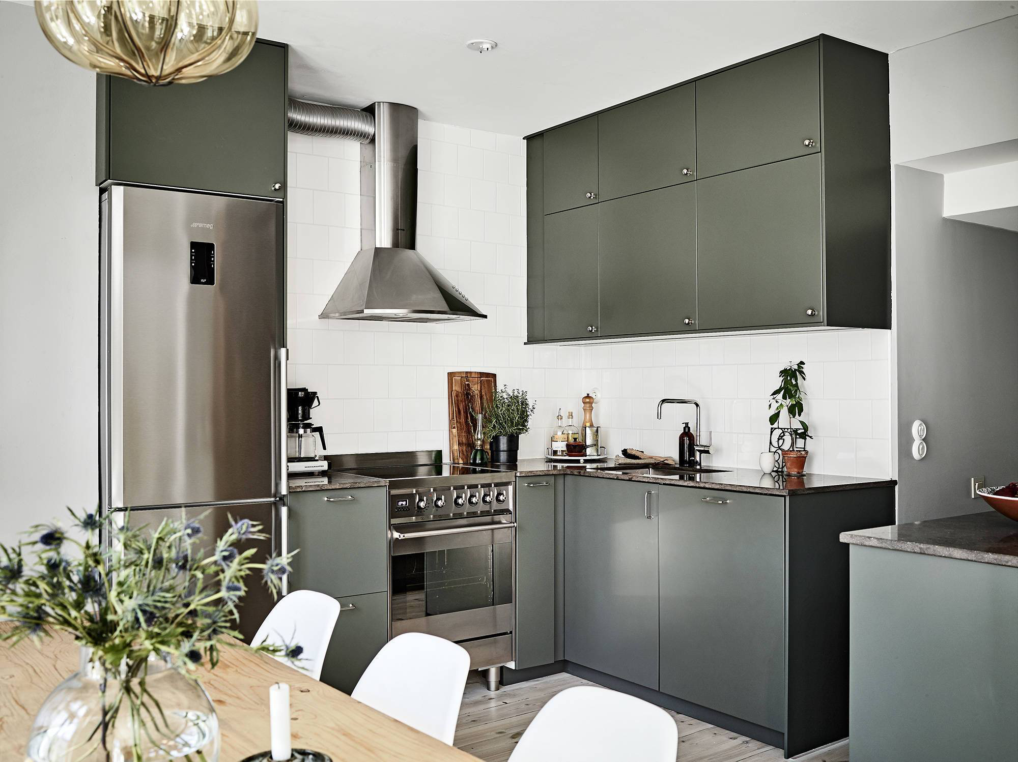  Hệ thống tủ lưu trữ ẩn trong nhà bếp với sắc màu xanh bàng bạc khiến không gian thêm phần nổi bật.