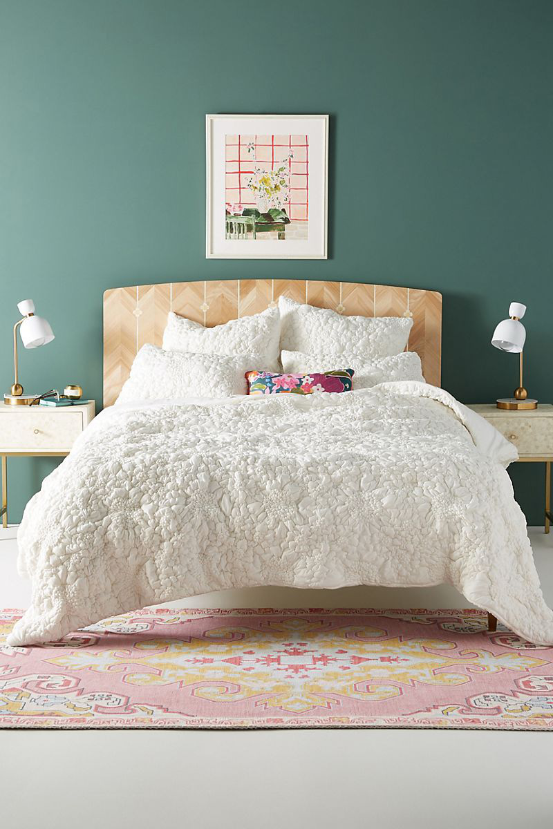  Sự kết hợp giữa giường gỗ, ga phủ trắng xốp và tường xanh rêu trong phòng ngủ.
