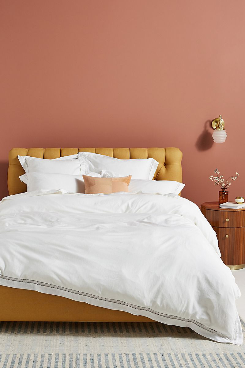  Phòng ngủ thoải mái với những bức tường màu hồng đất và một chiếc giường màu vàng mù tạt