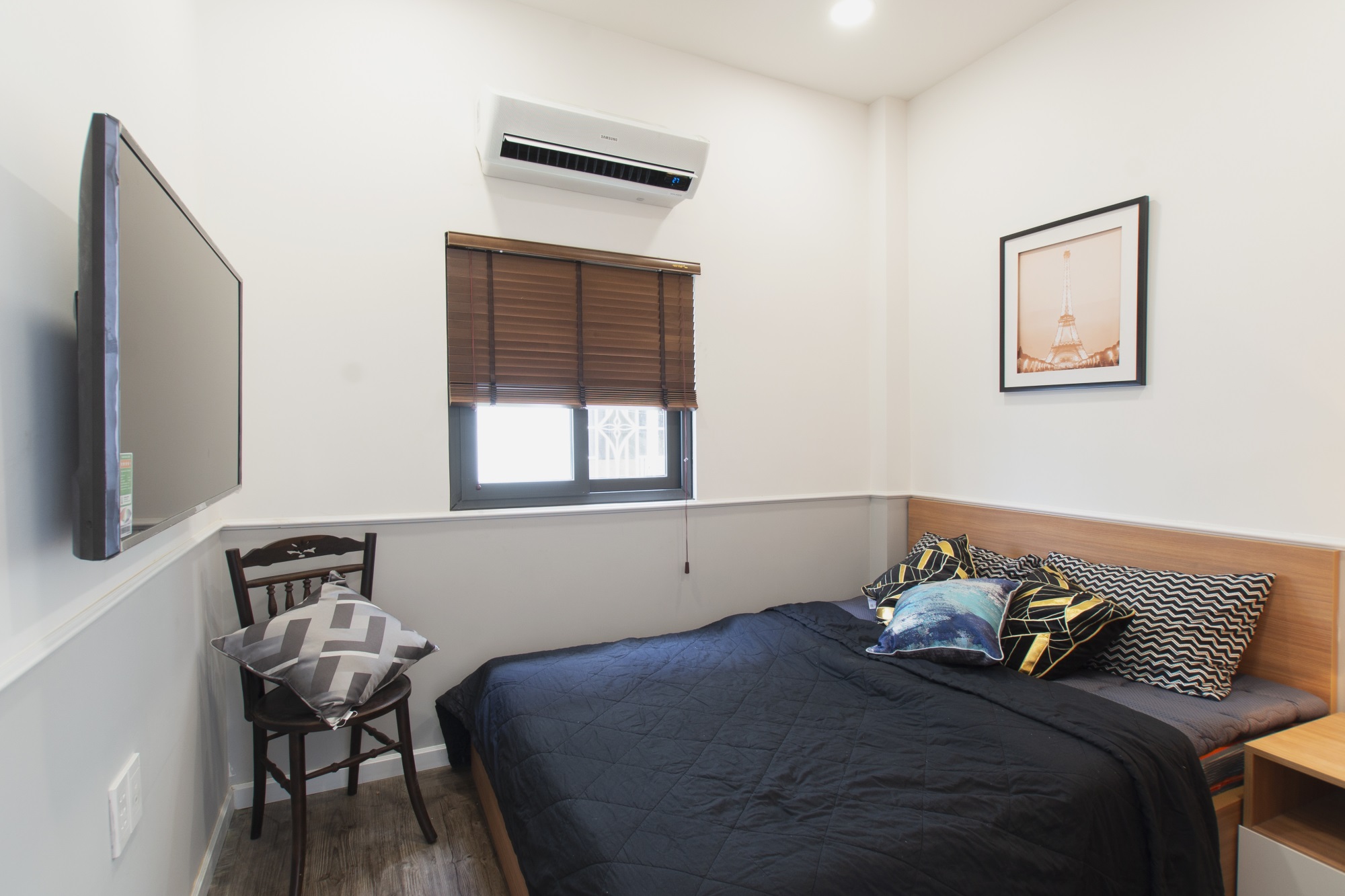  Không gian ngủ được thiết kế theo phong cách hiện đại, tối giản với tủ trang điểm và chiếc tivi treo tường.