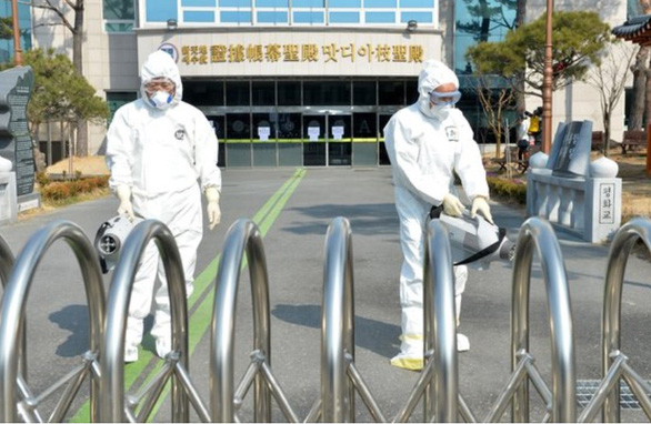  Nhân viên y tế thành phố Daegu khử trùng khu vực nhà thời của giáo phái Shincheonji (Tân Thiên Địa) hôm 20-2 - Ảnh: JoongAng Ilbo