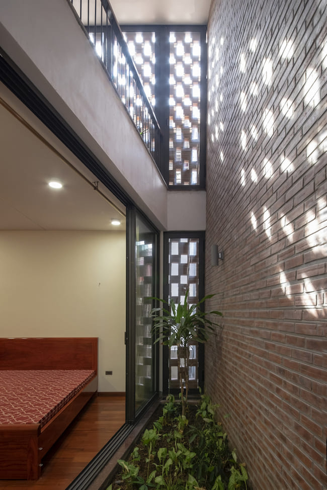  Căn phòng ngủ cũng lấy ánh sáng từ giếng trời và bức tường gạch đục lỗ. Không gian này cũng được ngăn cách với môi trường bên ngoài thông qua 2 bức tường và lớp cây xanh.