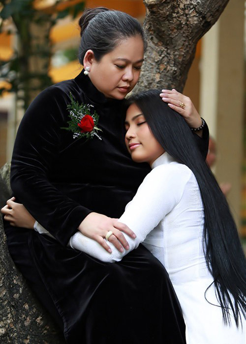  Trương Thị May chụp ảnh kỷ niệm cùng mẹ. Áo dài truyền thống được thiết kế trên tông màu tương phản với chất liệu nhung đen và lụa trắng.