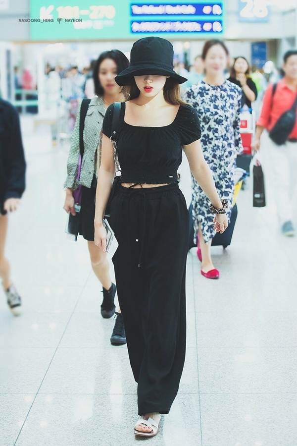  Phong cách thời trang chủ đạo của Na Yeon là trẻ trung và năng động. Trong một lần ra sân bay, Na Yeon gây ấn tượng với set đồ ăn rơ màu sắc gồm mũ bucket, croptop mix quần bo gấu màu đen.