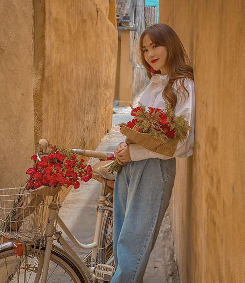 Áo trắng và quần jeans xanh là combo khá quen thuộc, khó lỗi mốt. Để giúp mình 'hack tuổi', phái đẹp có thể chọn kiểu áo blouse điệu đà để phối cùng quần vintage như Minh Hằng.