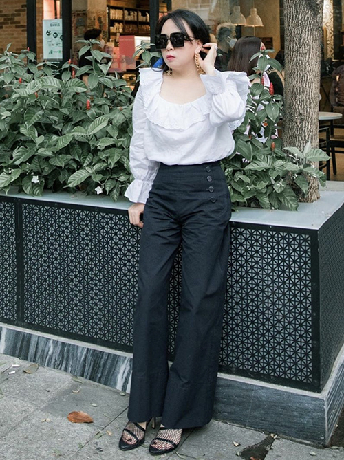  Giày cao gót tông đen được Phượng Chanel sử dụng đồng điệu cùng set đồ áo blouse, quần suông ống rộng, kính mắt to bản đồng màu.