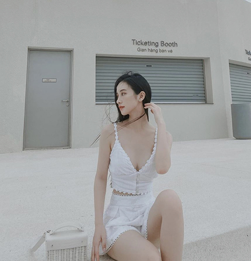 Jun Vũ chọn túi tre phối da trắng khi diện set đồ tôn nét gợi cảm được mix giữa áo hai dây và chân váy chữ A dáng ngắn.