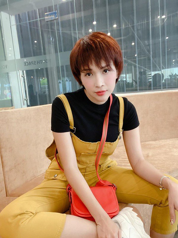  Khả Như trông vô cùng cá tính nhờ sự khéo léo khi chọn set đồ áo phông đen cùng quần yếm vàng.