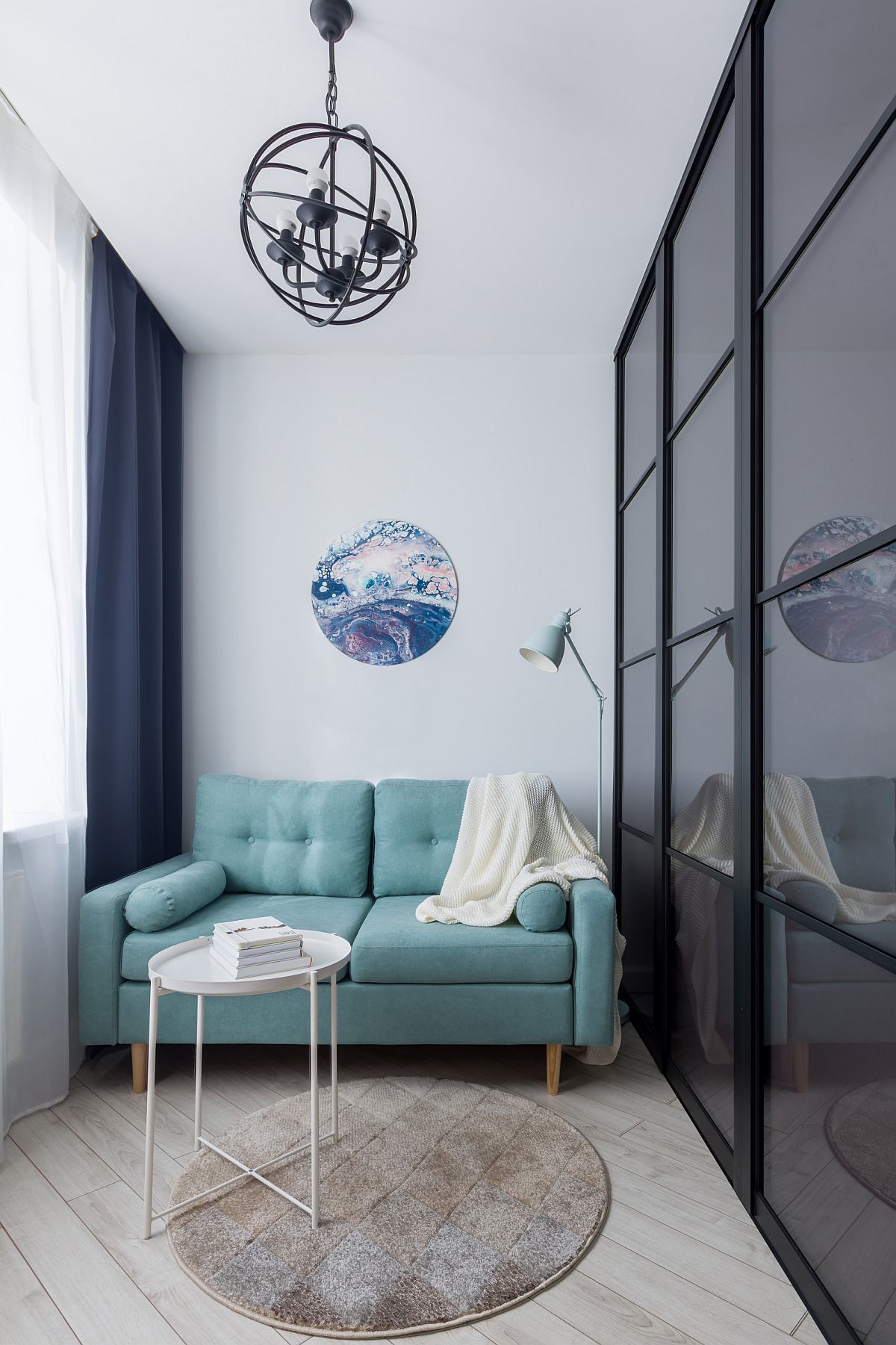  Phòng khách nhỏ với diện tích khá khiêm tốn nhưng vẫn vô cùng xinh xắn và đủ đầy khi được đặt sofa nhỏ gọn với màu xanh ngọc lam trẻ trung, bắt mắt.