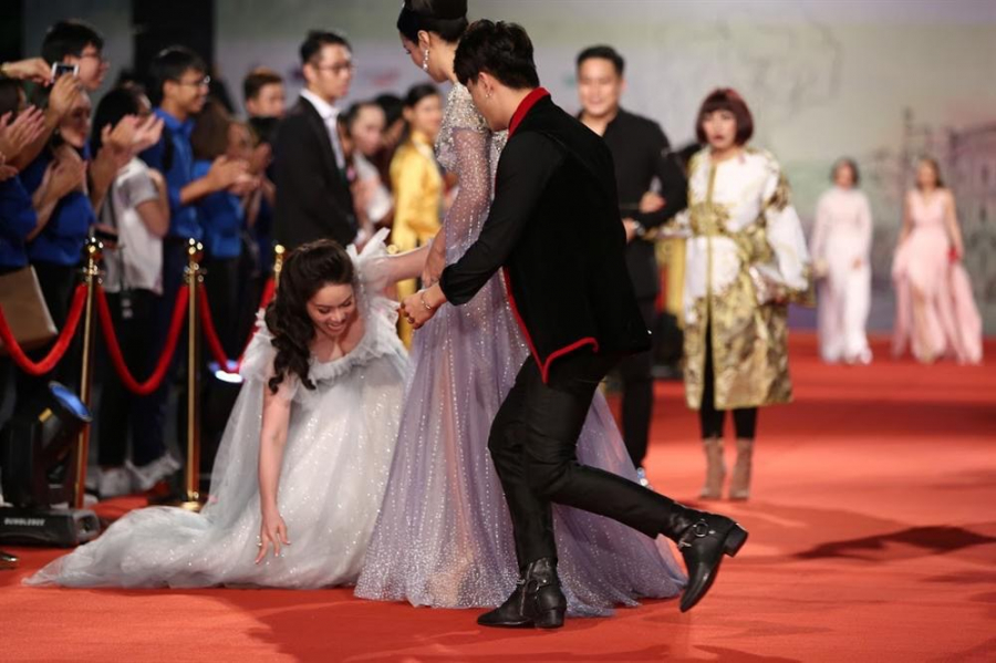  Nhật Kim Anh sánh bước cùng Hoa hậu Đền Hùng Giáng My và đàn em Ti Ti - HKT, cô chọn chiếc đầm bẹt vai o ép vòng một và phần thân váy xoè cồng kềnh bất tiện. Thậm chí là cô còn vô tình dẫm phải chân váy dẫn đến tình trạng bị 