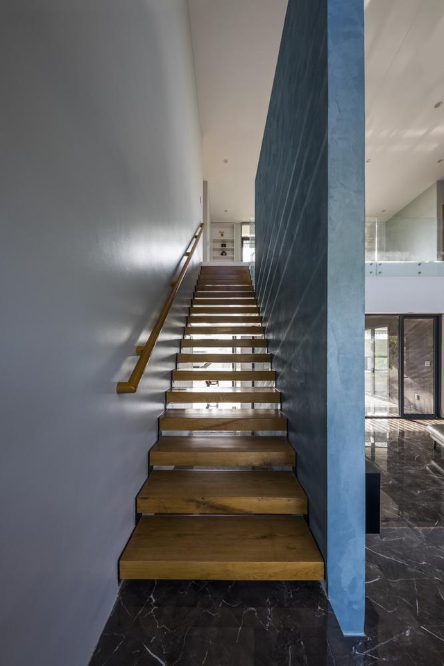  Cầu thang gỗ nhỏ gọn dẫn lối lên tầng hai. Thiết kế bậc hở cho phép ánh sáng chiếu xuyên qua và tạo độ thoáng nhất định cho không gian.