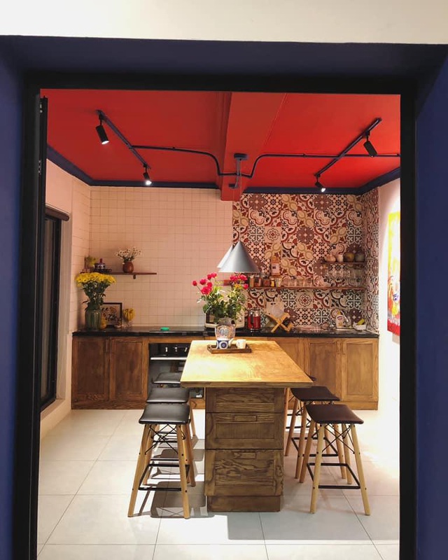  Để tạo ra sự thống nhất giữa mặt tiền và nội thất bên trong nhà, chị Hương sử dụng lại màu đỏ cho phần trần phòng khách (cũng là phòng sinh hoạt chung của xưởng bếp) và những chi tiết viền xanh sẫm ở gạch bông xi măng để tạo nên tổng thể thống nhất trong kiến trúc.