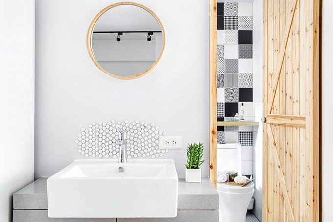Bồn rửa tay hình vuông đặt dưới gương tròn tạo thế cân bằng, cây xanh giúp khử mùi và tạo ra bầu không khí dễ chịu trong phòng tắm.