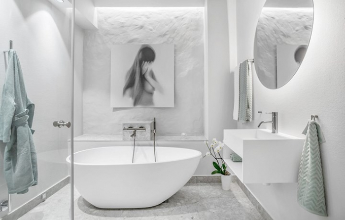 Phòng tắm sử dụng sơn tường và nội thất trắng, gương tròn giúp làm tăng chiều sâu cho phòng tắm.