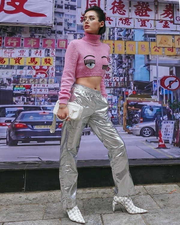 Khánh Linh The Face tạo nên phép cộng lý tưởng giữa crop top len hồng cổ trụ, quần ánh bạc và boots gót nhọn in họa tiết.
