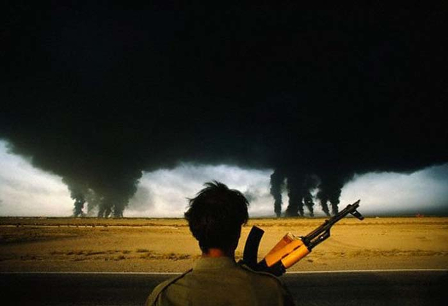 Người lính Iran hướng tầm mắt về những giếng dầu của Iraq có khói đen bốc lên ngút trời. Ảnh chụp năm 1980
