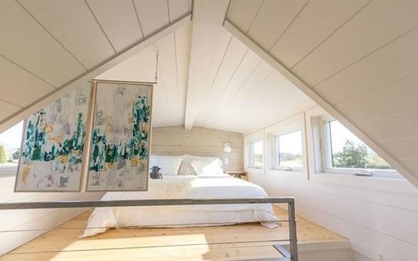 Giường ngủ trên gác mái ngập ánh sáng mặt trời.