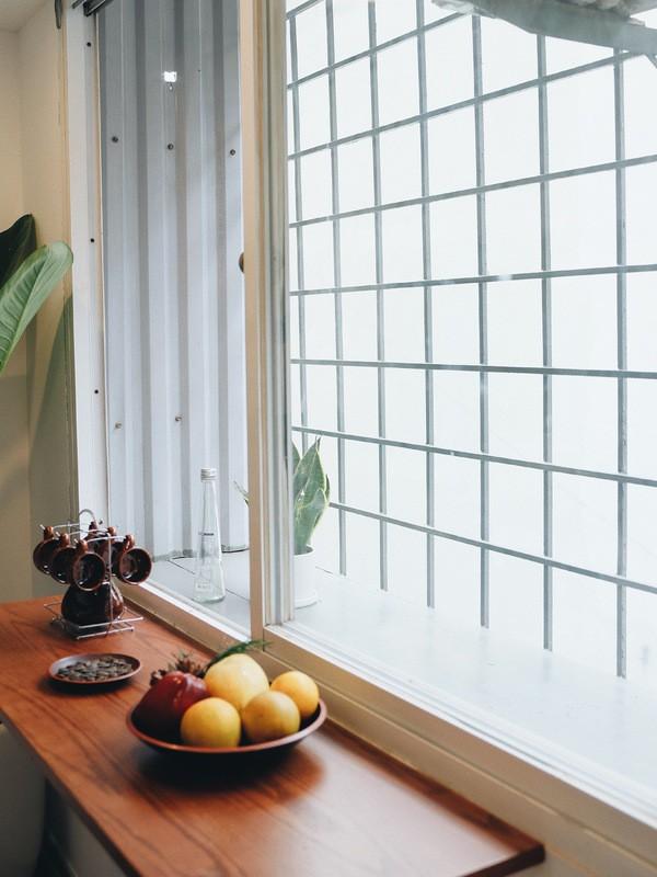 Một chiếc kệ gỗ được đóng thêm cạnh cửa sổ giúp gia chủ có thể thong thả uống trà, thưởng thức ăn ngắm khung cảnh bên ngoài.