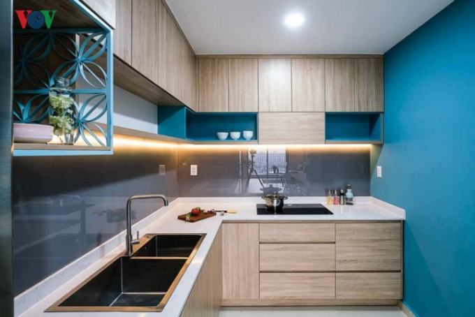 Khu bếp được thiết kế gọn gàng với màu nâu gỗ và màu xanh chủ đạo.