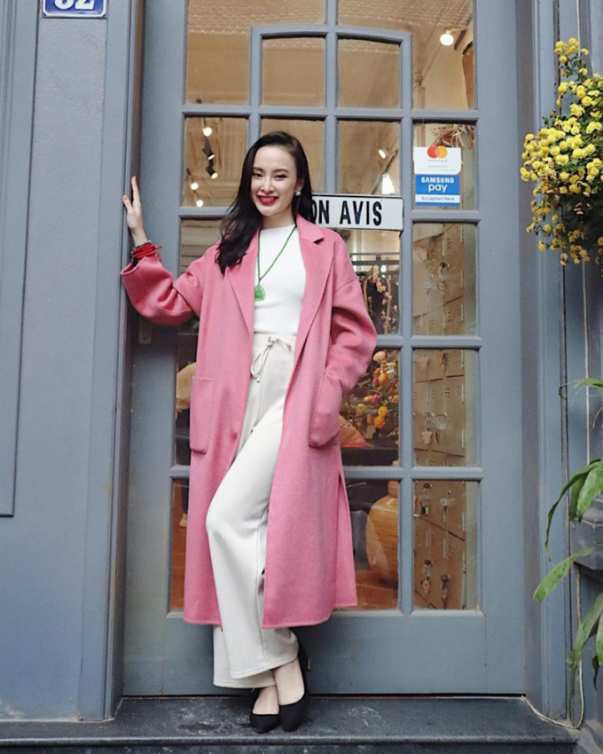 Tận hưởng thời tiết buốt giá của mùa đông Hà Nội, Angela Phương Trinh thích thú “thả dáng” trên phố với set đồ tuyền trắng, mix với chiếc áo khoác dài hồng phấn, vừa ấm áp lại tôn vẻ ngọt ngào.