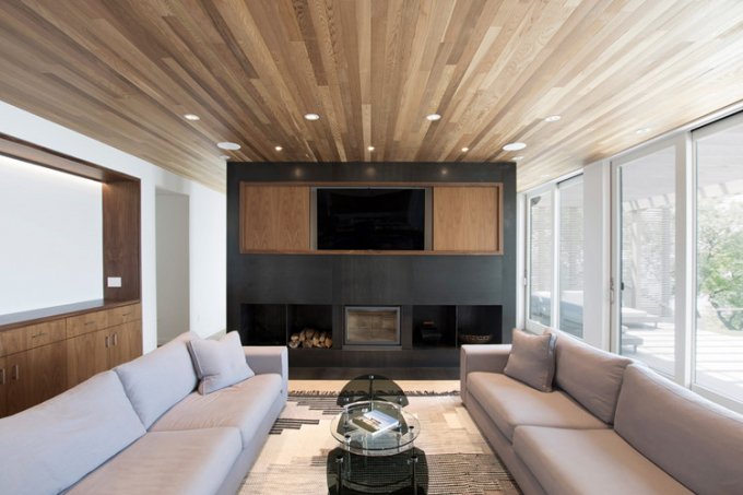 Phòng khách với trần nhà được ốp gỗ, tạo cảm giác sang trọng, ấm áp.