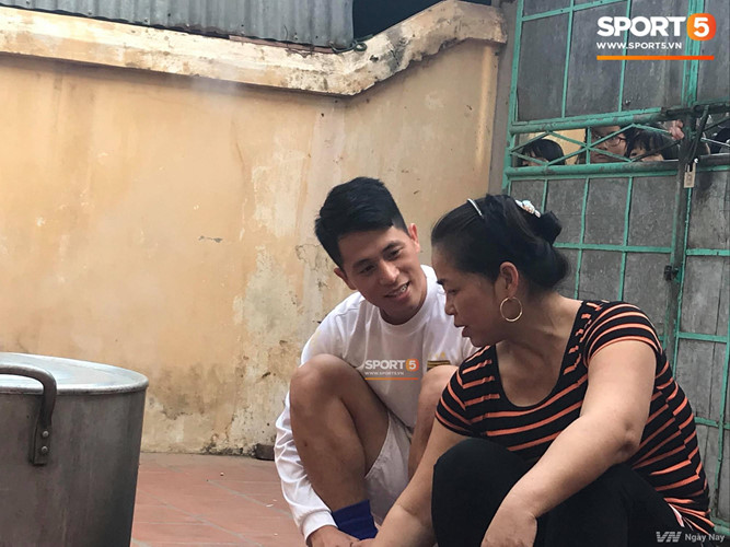 Trong khi đó, Đình Trọng ngồi bên bếp bánh chưng của mẹ Duy Mạnh để hỏi thăm và lắng nghe những chia sẻ trong cuộc sống. Ảnh: Sport5