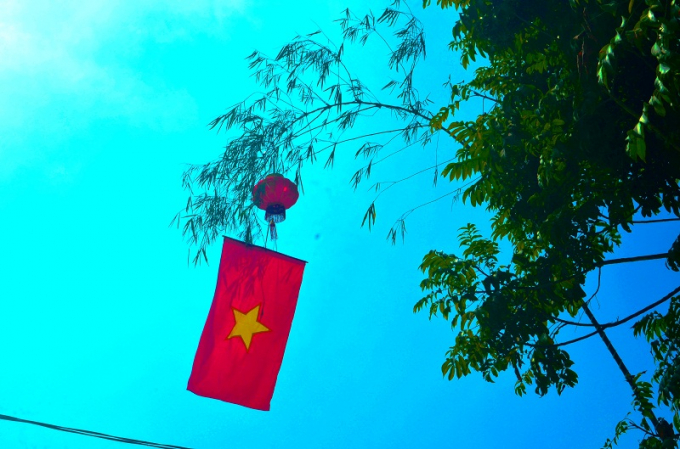 Treo cờ tổ quốc dưới ngay đèn lồng để cho lá cờ được tung bay mọi phía theo chiều gió là cách các hộ dân ở huyện Nghĩa Đàn trang trí rất nhiều.
