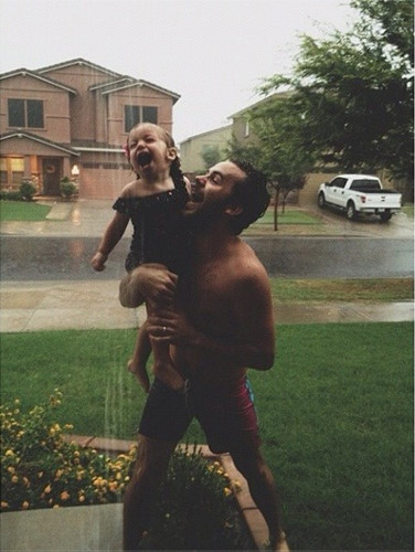 Hai bố con cùng tắm mưa một cách đầy phấn khích.