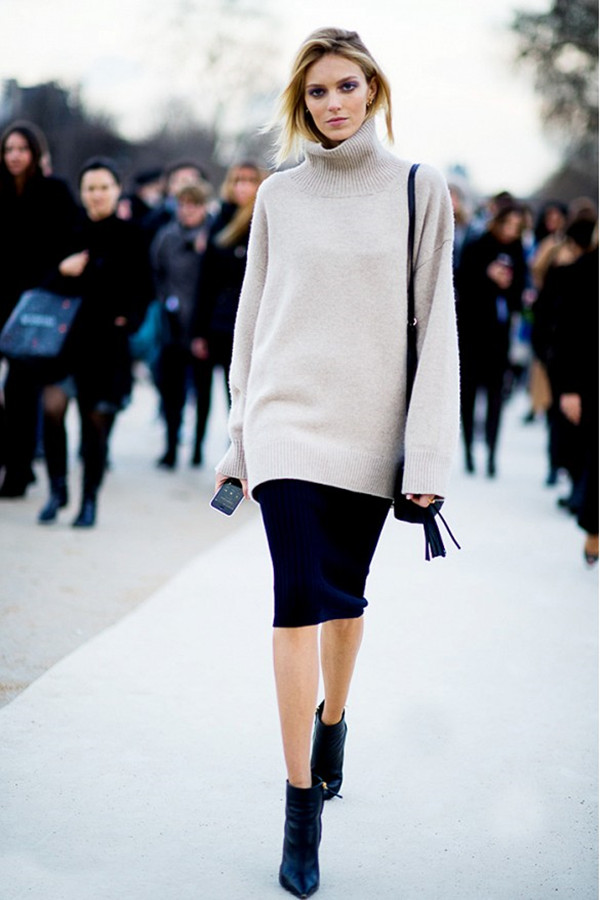 Người mẫu Anja Rubik ấn tượng trên phố với áo len cổ cao màu xám dáng rộng kết hợp cùng chân váy màu đen và bốt cao gót cổ thấp.