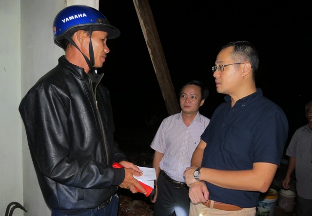 Chủ tịch UBND tỉnh Phú Yên Phạm Đại Dương (phải) thăm hỏi, hỗ trợ người dân bị thiên tai tại Hòa Tâm, đêm 18.11