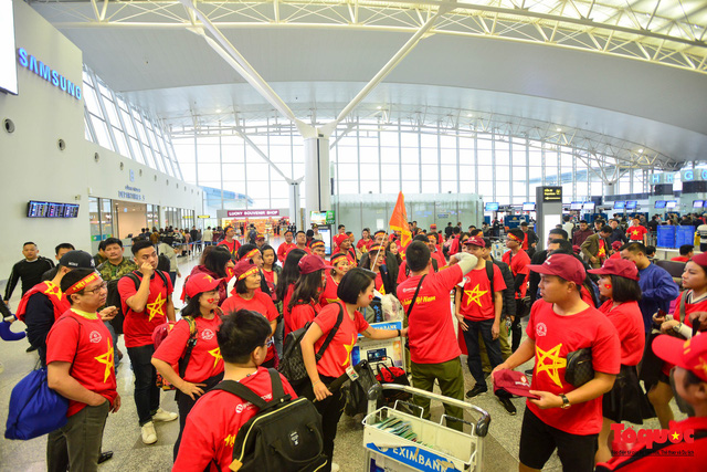 Sáng sớm, sảnh làm thủ tục tại nhà ga quốc tế đi của sân bay Nội Bài đỏ rực cờ đỏ sao vàng và các trang phục cổ động của người hâm mộ.