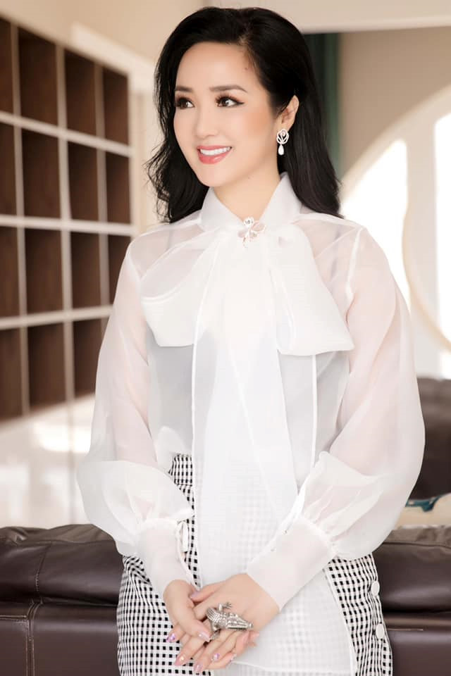 Hoa hậu Đền Hùng Giáng My khoe nhan sắc thanh lịch ở tuổi U50. Với gam màu đối lập đen - trắng, cô lựa chọn áo sơ mi tay phồng chất liệu lụa kết hợp cùng chân váy kẻ ô nữ tính.