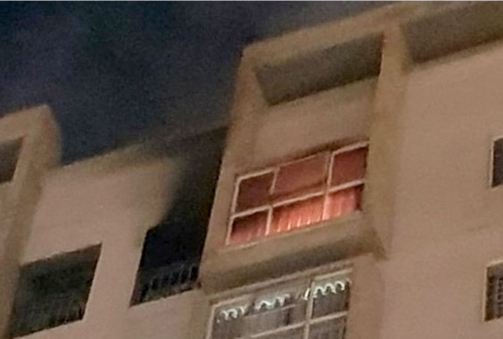  Lửa và khói bốc lên từ căn hộ 1107 tòa nhà 11CT05 đêm 26/7. (Ảnh: Đ.N)  