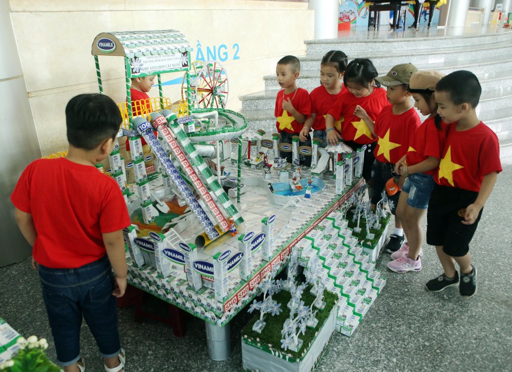  Phụ huynh học sinh và các em nhỏ thích thú xem các đồ dùng, đồ chơi, mô hình từ vỏ hộp sữa đã qua sử dụng tại Ngày hội SHĐ Đà Nẵng. 