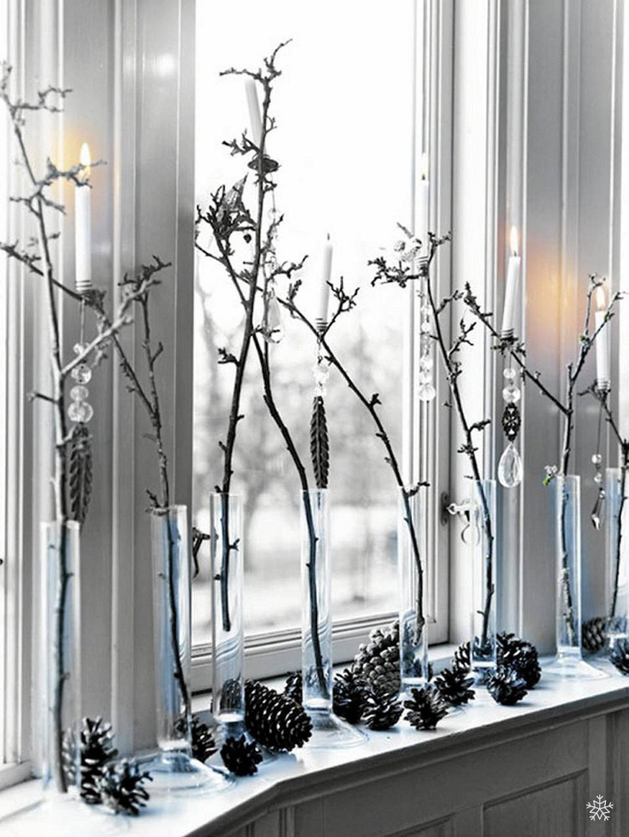  Các cành cây thông mảnh được cắm trong các ống thủy tinh trong suốt được để trang trí ở thành cửa sổ.