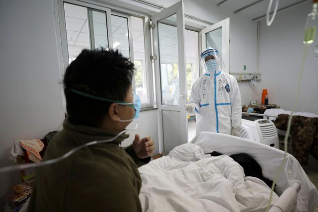  Nhân viên y tế mặc bảo hộ khi tiếp xúc với một bệnh nhân ở khu cách ly của một bệnh viện ở Vũ Hán hôm 13/2. (Ảnh: China Daily)