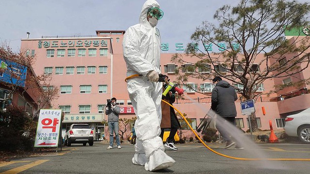  Nhân viên y tế Hàn Quốc khử trùng trước một bệnh viện nơi có các ca nhiễm virus corona. (Ảnh: Yonhap)