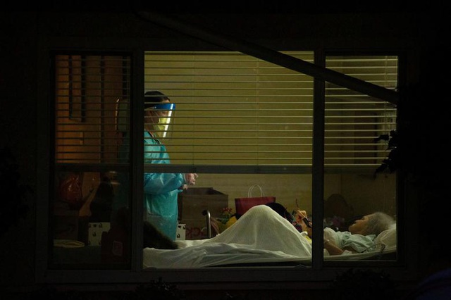  Một nhân viên y tế đang chăm sóc một bệnh nhân nhiễm virus corona tại trại dưỡng lão ở Kirkland, bang Washington, Mỹ. (Ảnh: Reuters)