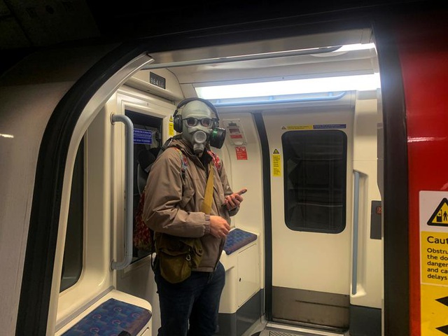  Một người đàn ông đeo dụng cụ bảo vệ kín mặt đi tàu điện ngầm ở London, Anh (Ảnh: Reuters)
