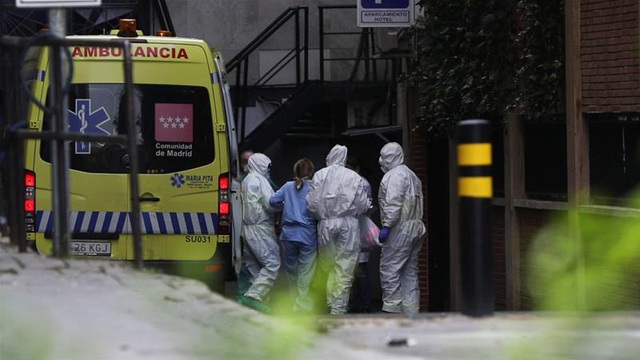  Nhân viên y tế đưa bệnh nhân tới một khách sạn được trưng dụng làm bệnh viện tạm ở Madrid (Ảnh: Reuters)