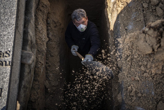  Một người làm nghề khâm liệm chuẩn bị phần mộ chôn cất nạn nhân Covid-19 ở nghĩa trang Almudena, Madrid, Tây Ban Nha (Ảnh: AP)
