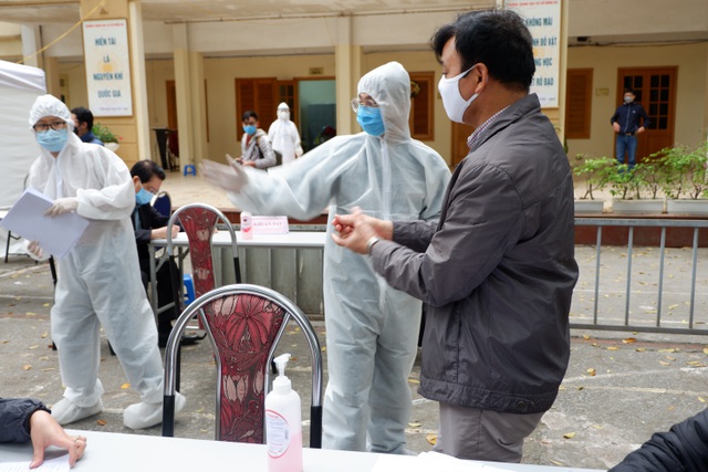  Khi đến lượt, người dân được cán bộ y tế hướng dẫn rửa tay sát khuẩn.