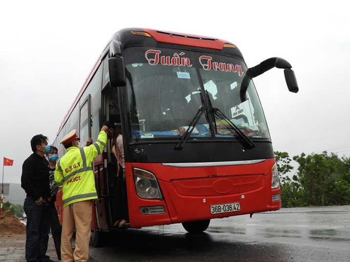 Lực lượng chức năng tiến hành kiểm tra, đo thân nhiệt của những người có mặt trên xe khách.
