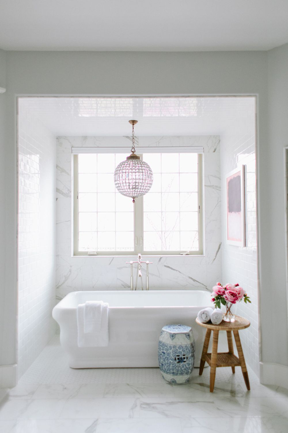  Sử dụng đèn chùm hoa oải hương và tác phẩm nghệ thuật, một chiếc ghế sứ màu xanh tuyệt vời và bồn tắm sang trọng giúp không gian phòng tắm này trông đơn giản nhưng không nhàm chán.