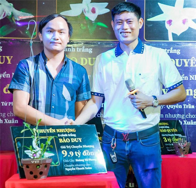  Anh Nguyễn Thanh Xuân (bên phải) cạnh chậu lan Bảo Duy 5 cánh trắng trị giá 9,9 tỷ đồng được chuyển nhượng hôm 10/6 vừa qua. (Nguồn: Nhịp Sống Việt - Tổ Quốc)