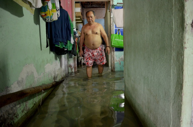  Ông Hà lội bì bõm trong ngôi nhà bị ngập nước lênh láng