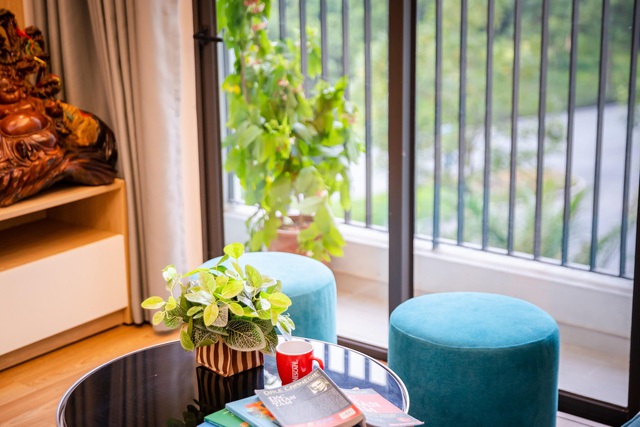  “Mọi góc trong nhà mình đều muốn tạo thành những không gian đọc sách thư thái. Thay vì sắp đặt quá nhiều đồ đạc cồng kềnh thì chiếc bàn phòng khách chỉ được điểm đơn giản bằng một chậu cây xanh nhỏ xinh”, gia chủ chia sẻ.