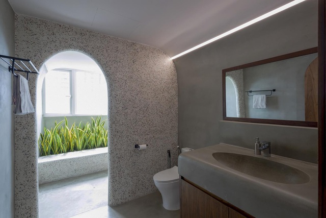  Tường đá mài có tông màu trung tính với đốm nhỏ mịn hơn trong một phòng tắm.
