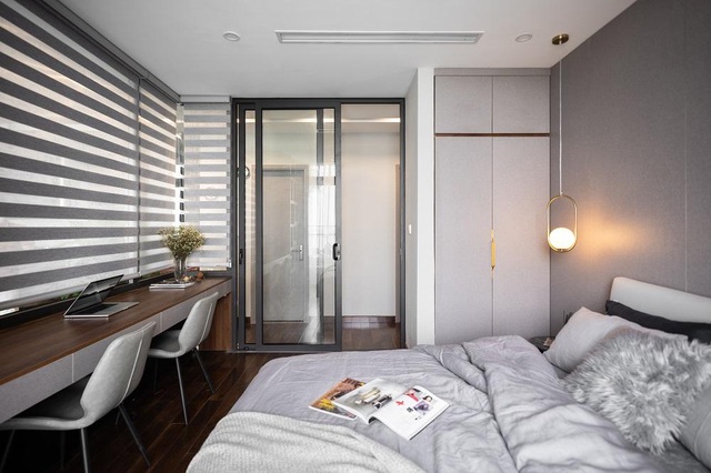  Phòng ngủ thứ 3 thiết kế khá đơn giản với tông màu xám. Bàn làm việc kéo dài sát tường cùng tủ quần áo nhỏ giúp tối ưu hóa không gian.